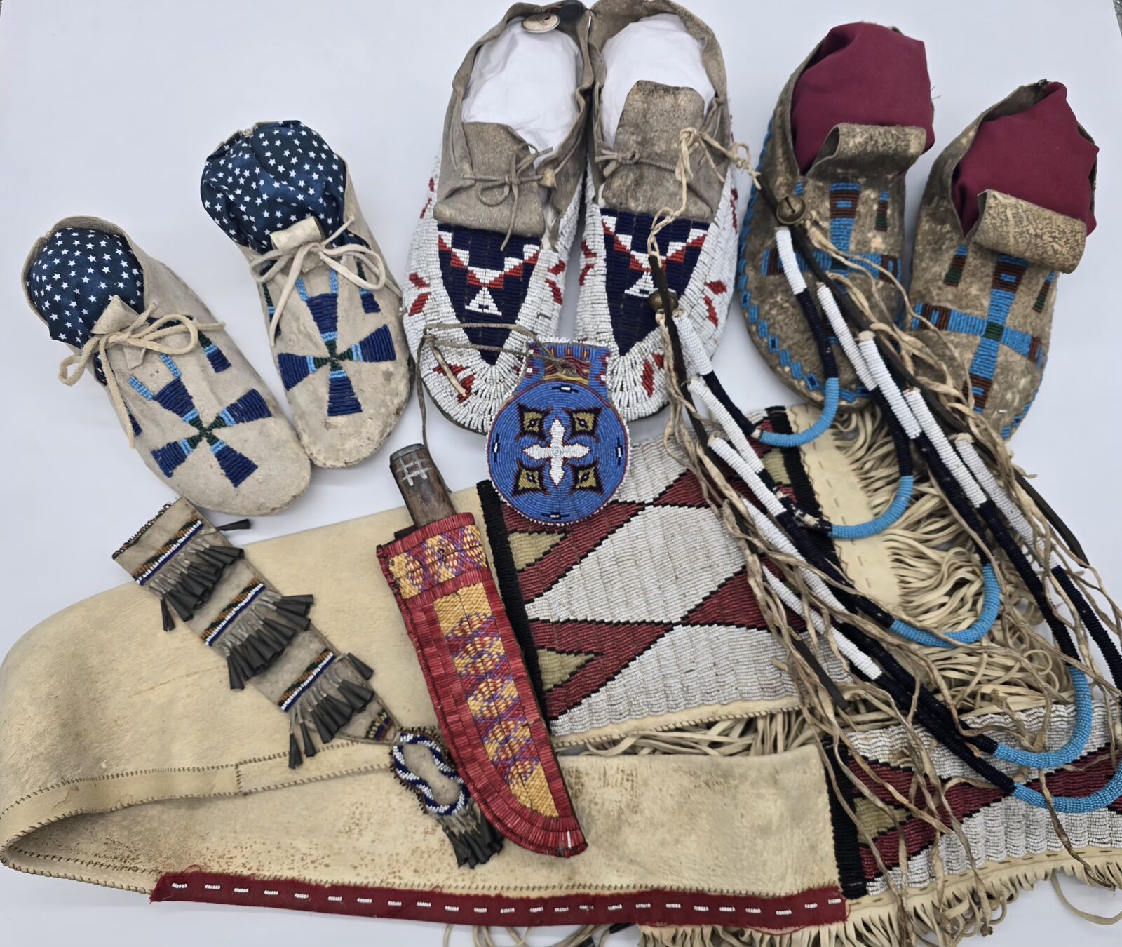 Beaded moccasins, a beaded knife sheath, a beaded pouch, and a fringed beaded hide strip