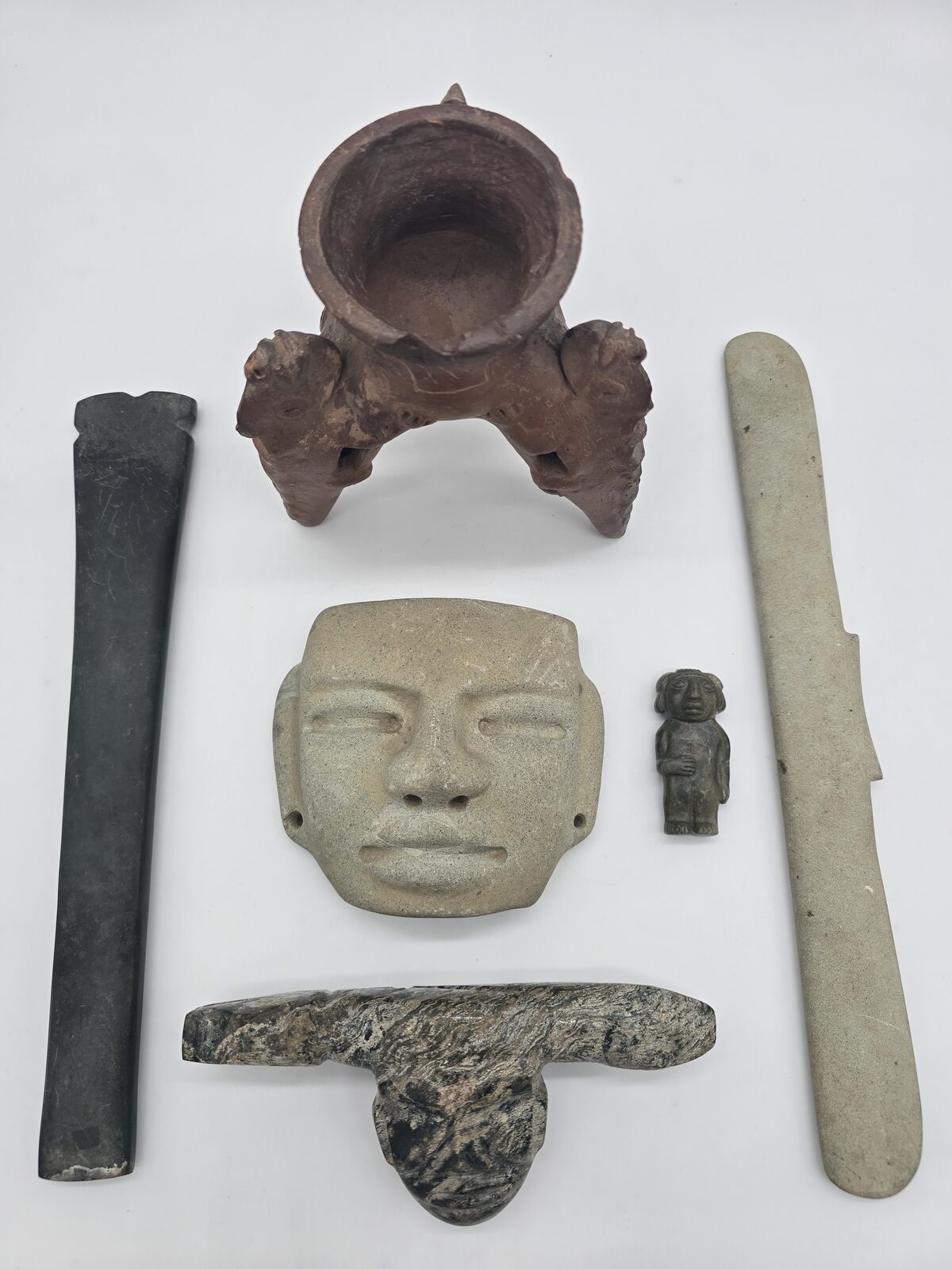 Pre-Columbian tripod vessel, carved stone mask, small standing figure, and stone tools